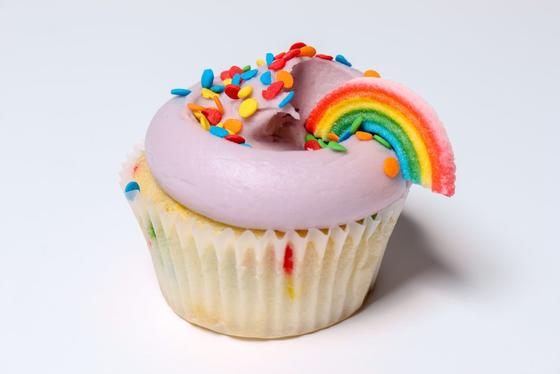 A deliciously Mason pink frosted and rainbow candy topped cupcake